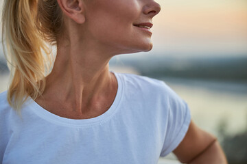 Woman with a pleased smile standing outdoors