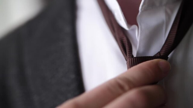 a man in a jacket tying a tie