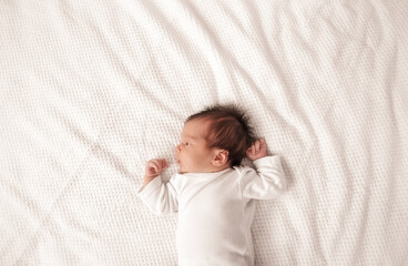 Cute newborn baby girl lying in the bed