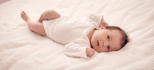 Cute newborn baby girl lying in the bed