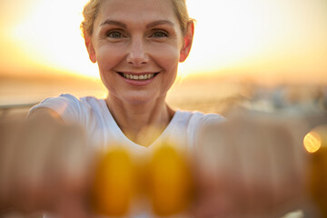 Cheerful strong woman working out with weights