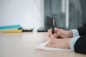 Close up business man writing or signing contract on paper in office..