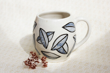 handmade ceramic cup with leaves. clay covered with engob, glaze and passed two firing.