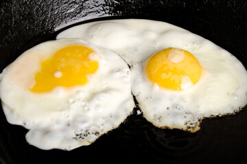 two scrambled eggs in a pan close-up