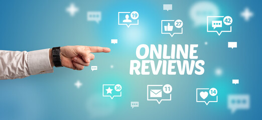 Close-Up of cropped hand pointing at ONLINE REVIEWS inscription, social networking concept