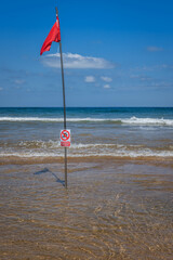 Red flag on the beach. Swimming and surfing ban
