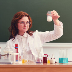 A scientist looks at the reaction of a white turbid chemical liquid. Experiments with chemical...
