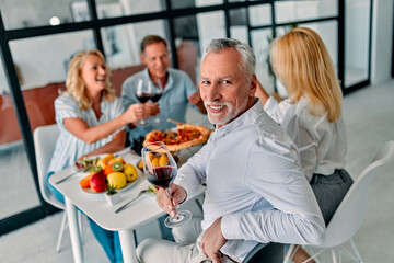 Senior friends having dinner at home