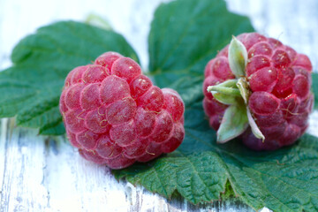 Berries background. Red raspberries on a wooden background close-up.Texture of raspberries.Horizontal, nobody, free space, close-up.