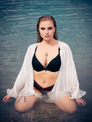 Obraz premium Sexy glamorous young woman kneeling in water