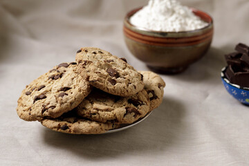 Dish of home made chocolate cookies with flower bowl in the background