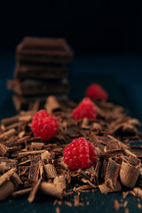 Chocolate with chocolate shavings and raspberry the dark wooden background