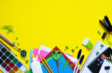 Back to school. School supplies on a yellow background. Layout of school accessories.
