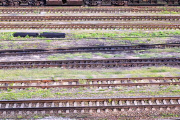 Railroad rails green grass black fuel oil sleepers