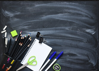 Back to school. School supplies on the blackboard. Layout of school accessories.