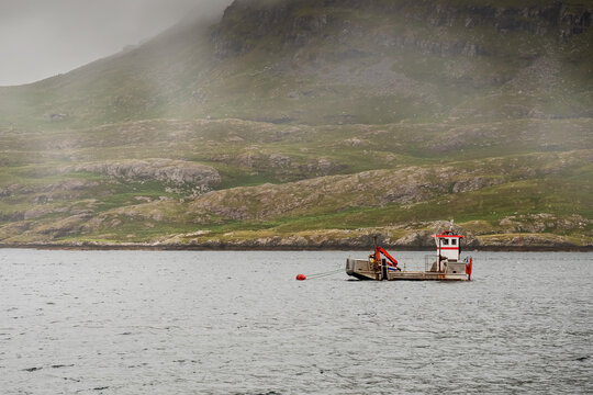 Small fish farming boat in the ocean, Mountains in the background. West of Ireland. Fresh fish industry concept.