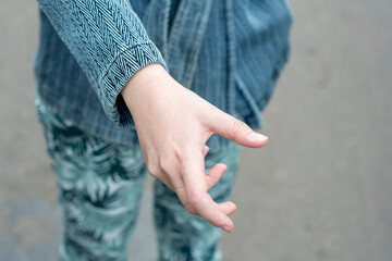 A close-up of a hand outstretched forward with the intention of opening the door. Hand outstretched in a gesture to open the handle.