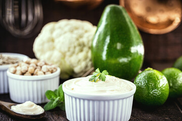 vegan mayonnaise, concept photo, mayonnaise made from vegetables without eggs or milk. Avocado cream, chickpeas, lemon, cabbage and sunflower seed.