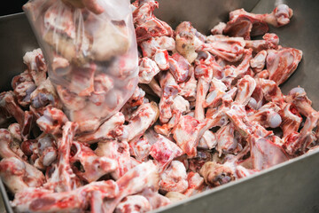 Close up of bloodied bones and meat used as waste in food processing butchery plant