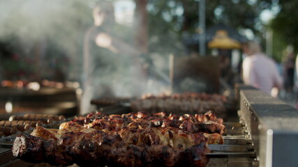 Shish kebabs preparing on skewers outdoors. Chef male cooking meat outside
