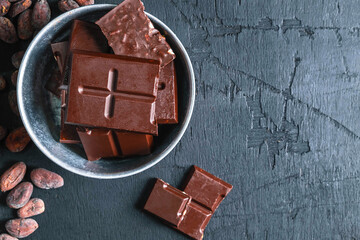 Dark chocolate bars on a wooden table.
