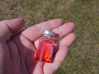 red bottle with medicine in hand
