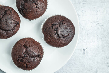 bakery chocolate cupcakes in a dish on a white background