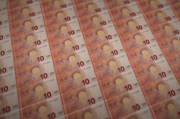 10 euro bills printed in illegal money production conveyor. Collage of many fake bills. Concept of...