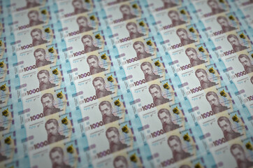 1000 Ukrainian hryvnias bills printed in illegal money production conveyor. Collage of many fake...