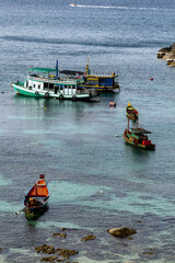 divers boat and longtail boat in a cove of Kot Tao © hectorchristiaen