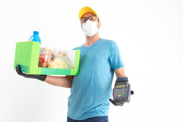 Fototapeta na wymiar Delivery guy with protective mask holding box / bag with groceries and POS for contactless payment.