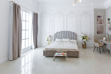chic luxury interior in an old antique style open-plan apartment decorated with columns and stucco on the wall in pastel colors. tiles on the floor. beige walls