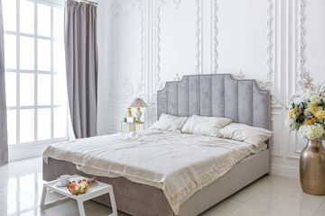 chic luxury interior in an old antique style open-plan apartment decorated with columns and stucco on the wall in pastel colors. tiles on the floor. beige walls