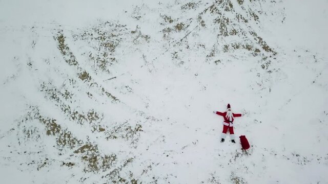 Santa Claus is lying on the snowy beach. Top view. Santa in the arctic