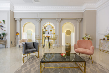 chic luxury interior in an old antique style open-plan apartment decorated with columns and stucco on the wall in pastel colors. tiles on the floor. beige walls