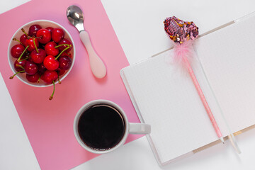 Still life with cup of coffee, sweet cherries, notebook, pink heart pen on white background. Creative minimalism purple flat lay. Summer template for feminine blog, female social media copy space.