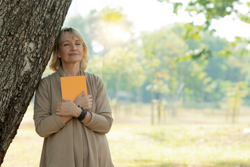 Dream and hope concept, old woman holding book and relax with close eye to think and dreaming under...