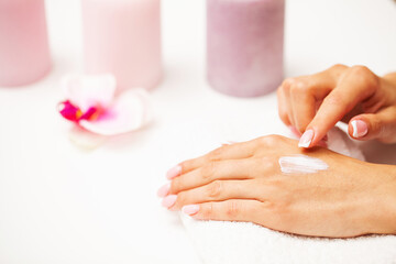 Obraz na płótnie Canvas Closeup of beautiful female hand applying hand cream