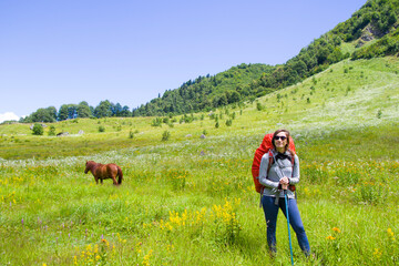 Hiker and backpacker in the mountain valley and field, trekking and hiking scene in Svaneti, Georgia