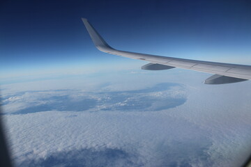 Obraz premium view to space from airplane above the clouds and left wing
