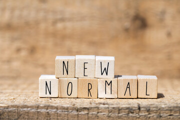 NEW NORMAL text on wooden cube. New normal life after covid-19 pandemic with social distancing and...