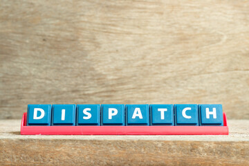 Tile letter on red rack in word dispatch on wood background