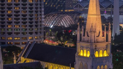 St. Andrew's Cathedral aerial day to night transition timelapse. It is an Anglican cathedral in Singapore, the country's largest cathedral. Skyscrapers on a background