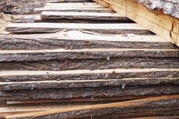 unedged lumber, stacked open air close up