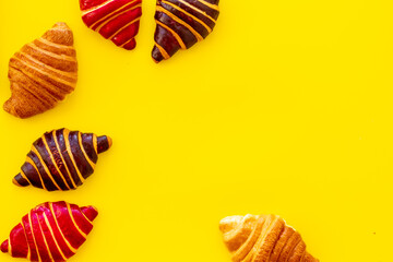 Set of croissants - chocolate, berry, classic - on yellow background top view