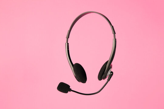 Online Technical Support Service. Call Center, Helpline. Headphones With Microphone On Pink Background.