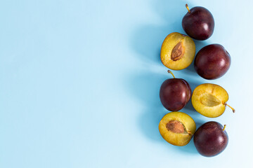 plum slices on a blue background. Top view with copy space