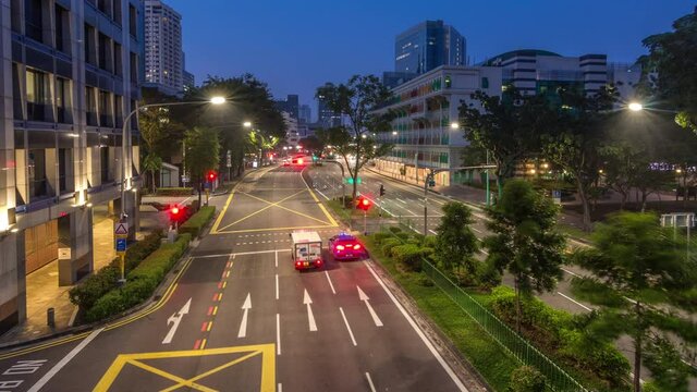Traffic on Hill Street near Old Police Station historic building in Singapore night to day transition aerial timelapse. Neoclassical style building with colorful windows. Skyscrapers on a background
