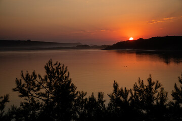 Obraz premium Beautiful orange sunset in the river to the sea