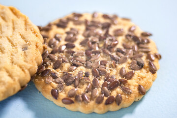 Heap of cookies with flax seeds on blue background